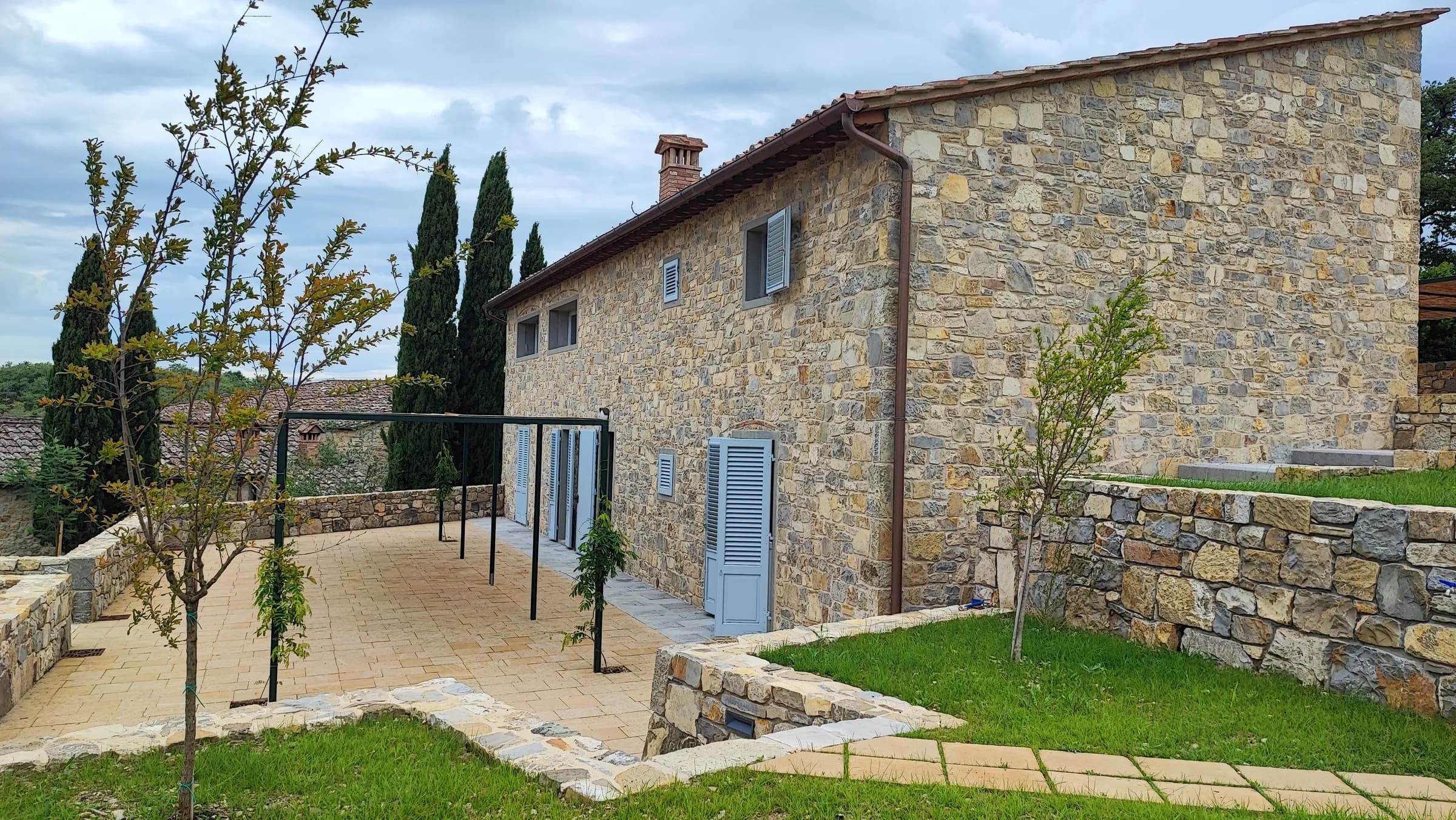 L'abitazione in pietra con il giardino e il terrazzo pavimentato